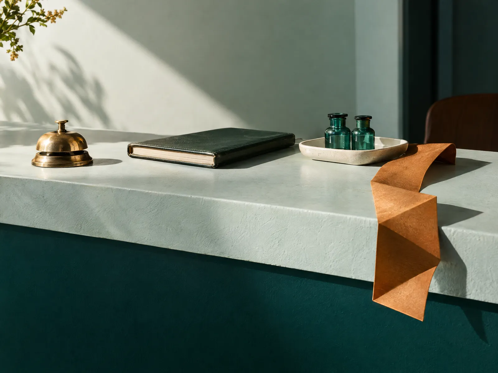 Clinic reception counter with a brass bell, an appointment book, two vials and an amber ribbon